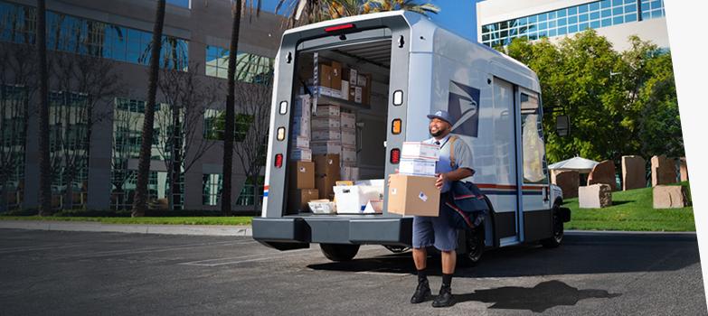 邮差准备递送从美国邮政新一代快递车后面卸下的包裹.